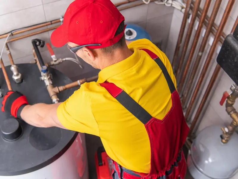 commercial plumber fixing water heating system